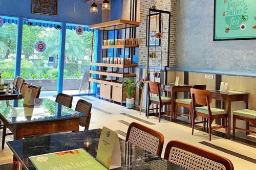 - un restaurant avec des tables et des chaises dans une salle dans l'établissement The Grace Residency, Lucknow, à Lucknow