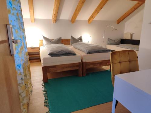 - 2 lits dans une chambre avec un tapis vert dans l'établissement Estelada Boarding Houses Zorneding, à Zorneding