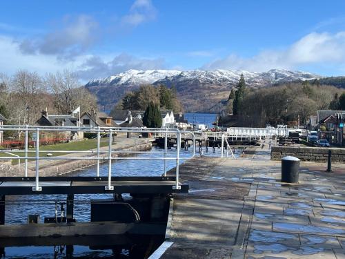 a bridge over a river with mountains in the background at Ness View Cottage in Fort Augustus