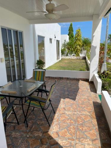Un patio con una mesa y sillas en una casa. en Ibiza beach residence Villa, en Nancito