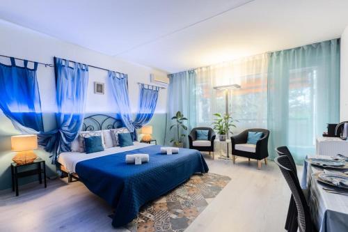 Schlafzimmer mit blauem Bett und blauen Vorhängen in der Unterkunft Lake Apartment 4 in Bissone