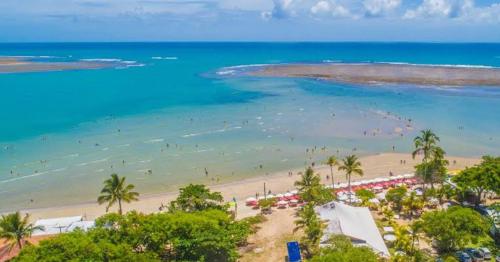 - une vue aérienne sur une plage avec des personnes dans l'eau dans l'établissement Pousada Verdes Mares, à Santa Cruz Cabrália