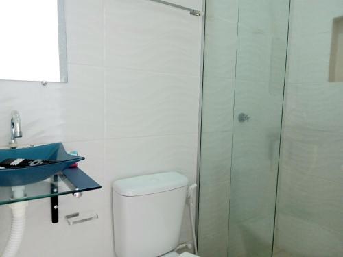 a bathroom with a toilet and a glass shower at Pousada Mazolas in Salinópolis