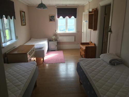 エンシェーピングにあるEnköping Cottageのベッドルーム1室(ベッド2台、テーブル、デスク付)