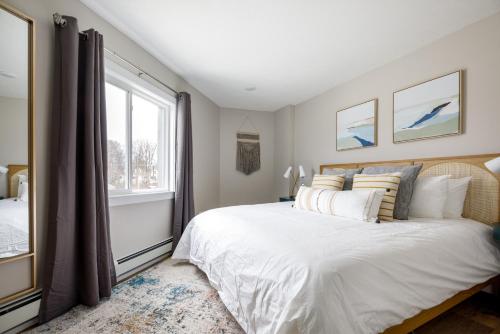 Un dormitorio con una cama grande y una ventana en Downtown Newly Remodeled Apartment AC Beach Restaurants Breweries Nightlife, en Traverse City