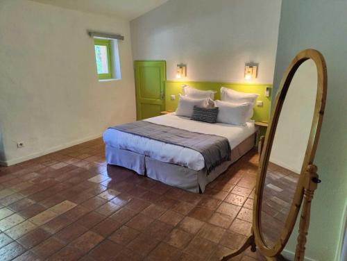 a bedroom with a large bed and a mirror at Le Mas des Laurels in Chantemerle-lès-Grignan