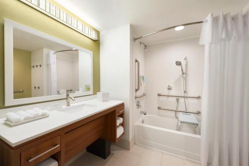 a bathroom with a sink and a tub and a mirror at Home2 Suites by Hilton Milwaukee Brookfield in Waukesha