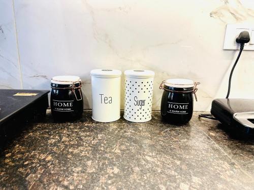 a group of three coffee cups sitting on a counter at Divine Inn Hotel Near Rajouri Garden Main Market in New Delhi