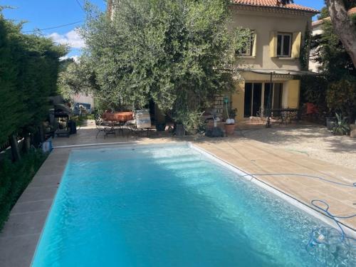 une grande piscine bleue devant une maison dans l'établissement Maison idéale pour famille proche de toutes commodités, à Carpentras