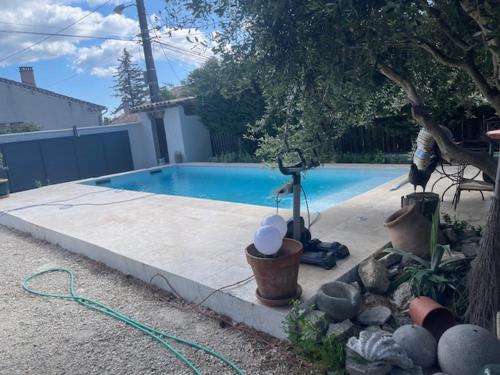 une piscine avec un tuyau à côté d'une cour dans l'établissement Maison idéale pour famille proche de toutes commodités, à Carpentras