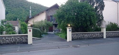 a house with a stone fence and a driveway at Les Ecureuils in Revin