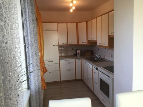 a small kitchen with white cabinets and a sink at Haus im Grünen in Bad Zell