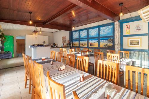 a dining room with a long table and chairs at Garden 437 Suítes in Florianópolis