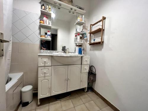 La salle de bains blanche est pourvue d'un lavabo et d'une baignoire. dans l'établissement Appartement très bien situé avec parking privé, à Montpellier