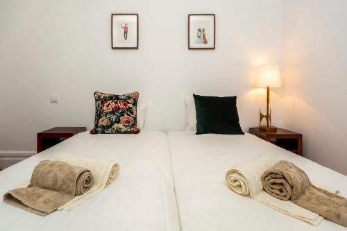 - 2 lits dans une chambre avec des serviettes dans l'établissement Classy Belas Artes, à Porto