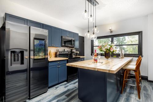 cocina con armarios azules y encimera de madera en Casa Del Exotique Walk Everywhere AC Beach, en Traverse City