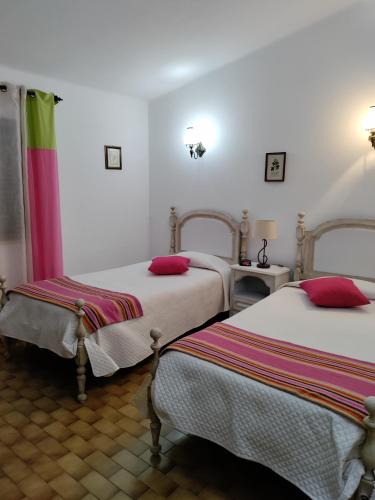 a room with two beds with red pillows at Villa Cristina e Ricardo in Carvoeiro