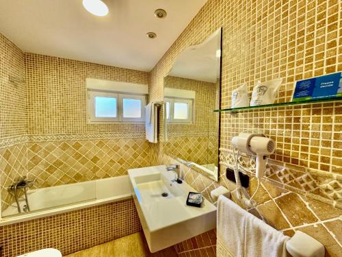 Hotel La Rivera في اريناس دي كابراليس: حمام مع حوض ومرآة