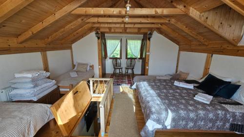 a attic room with two beds and a table at Vacation Home Gaj in Visoko
