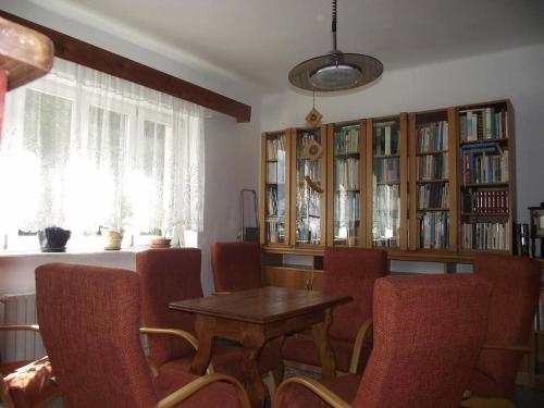 a dining room with a table and chairs and book shelves at Jandlova Vila in Frenštát pod Radhoštěm