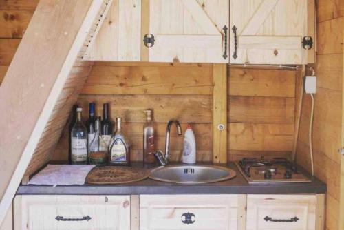 a kitchen with a sink and bottles of wine at Mavric Cabin in Ulcinj