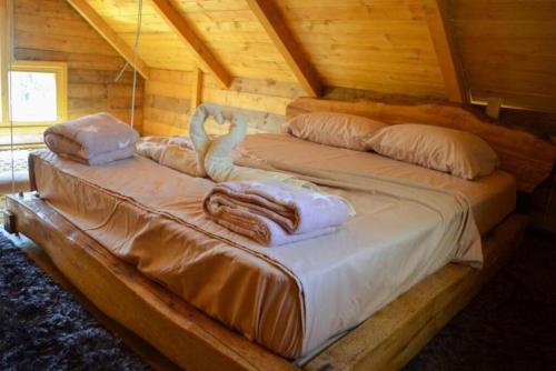 dwa łóżka w drewnianym domku z ręcznikami w obiekcie Mavric Cabin w Ulcinju