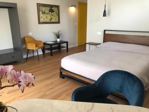 a bedroom with a bed and a table and a chair at Roggia Maestra B&B in Schio