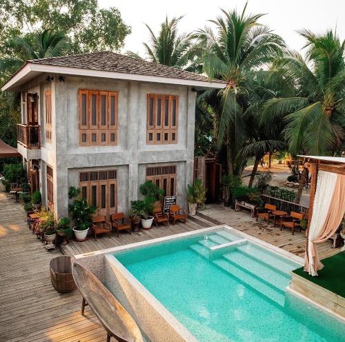 una casa con piscina frente a una casa en House Of Passion Amphawa, en Amphawa