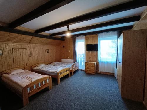 a bedroom with two beds and a television in it at Willa Alaska in Karpacz