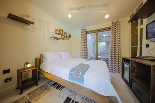 1 dormitorio con 1 cama grande y TV en Brera Alacati - Special Category, en Alacati