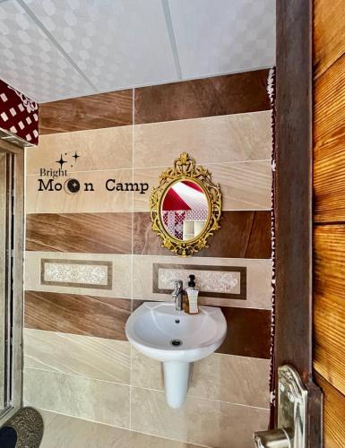 een badkamer met een wastafel en een spiegel aan een muur bij Rum Bright Moon Camp in Wadi Rum