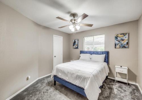 um quarto com uma cama azul e uma ventoinha de tecto em 4 Bedroom Suburban Dream House - SeaWorld-6Flags-MedCenter - Sleeps 10 em San Antonio
