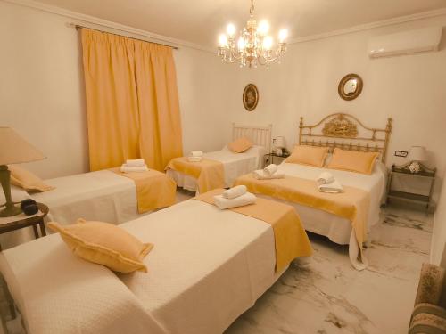 Cette chambre comprend 3 lits et un lustre. dans l'établissement Esmeraldas Vivienda Rural, à Villacarrillo