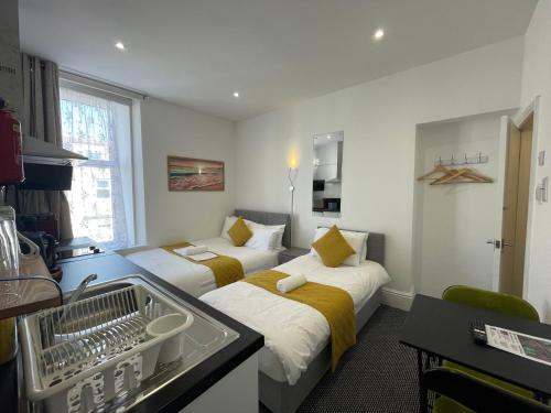 プリマスにあるStation House Plymouthのベッド2台とキッチン付きのホテルの部屋