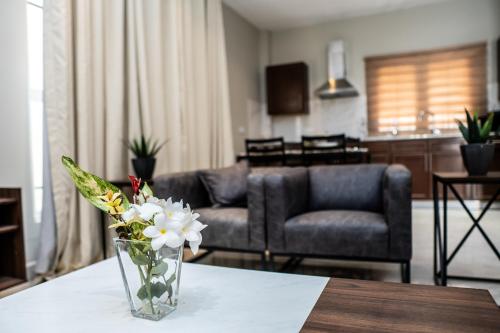 a vase of flowers on a table in a living room at ZURI Town Homes in Kololi