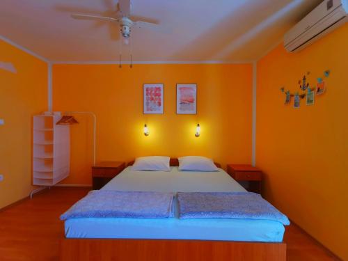 - une chambre dotée d'un lit avec un mur orange dans l'établissement Beach apartment Roza Biograd oneroom+, à Biograd na Moru