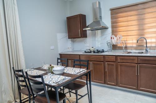 a kitchen with a table with chairs and a sink at ZURI Town Homes in Kololi