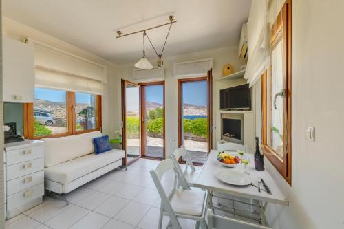 a living room with a couch and a table and chairs at Villa Marenosta in Ermoupoli