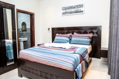 a bedroom with a large bed with a wooden headboard at ZURI Town Homes in Kololi