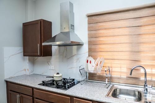 a kitchen with a stove top and a sink at ZURI Town Homes in Kololi