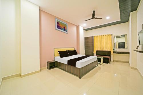 a bedroom with a bed and a chair in it at OYO Hotel Agrawal Inn in Bhopal