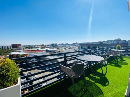 a balcony with tables and chairs and a view of the city at DEE-LOFT 53 in Windhoek