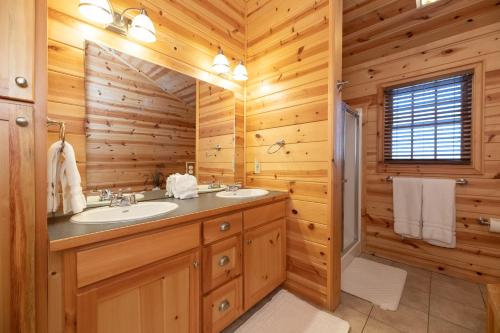 - une salle de bains en rondins avec deux lavabos et une fenêtre dans l'établissement Our Get Aweigh - Cabin Retreat - private hot tub - community pool - Goshorn Lake Access, à Saugatuck