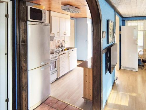 cocina con electrodomésticos blancos y paredes azules en 9 person holiday home in SÖLVESBORG-By Traum, en Sölvesborg