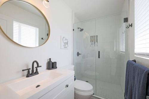 uma casa de banho com um chuveiro, um lavatório e um espelho. em Old Town Scottsdale Heated Pool em Scottsdale