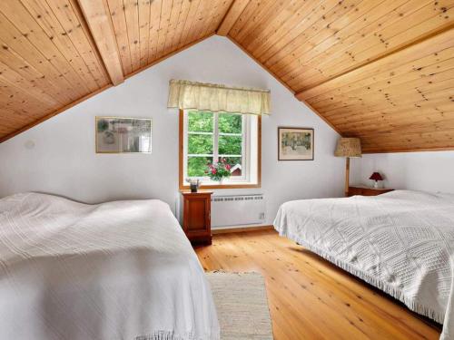 a attic bedroom with two beds and a window at 6 person holiday home in STRÖMSTAD-By Traum in Strömstad