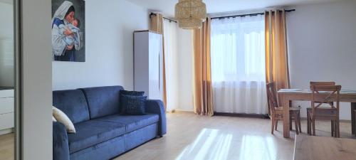 a living room with a blue couch and a table at Miriam Apartment Kraków Borkowska in Kraków