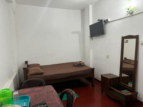 Cette petite chambre comprend un lit et un miroir. dans l'établissement Madura Rest, à Kandy