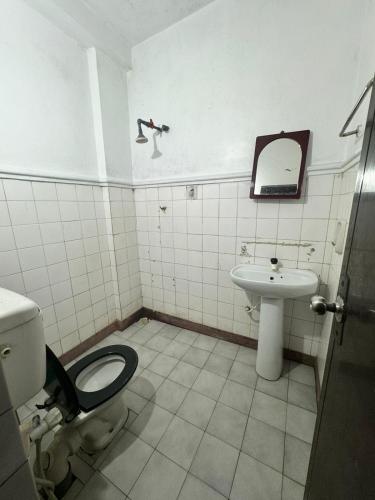 La salle de bains est pourvue de toilettes et d'un lavabo. dans l'établissement Madura Rest, à Kandy