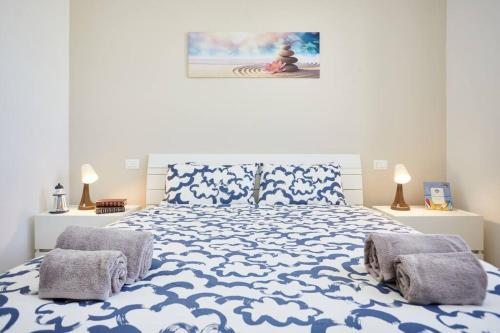 a bedroom with a blue and white bed with two pillows at Lux Apartment Aviano Centro AC Parking in Aviano